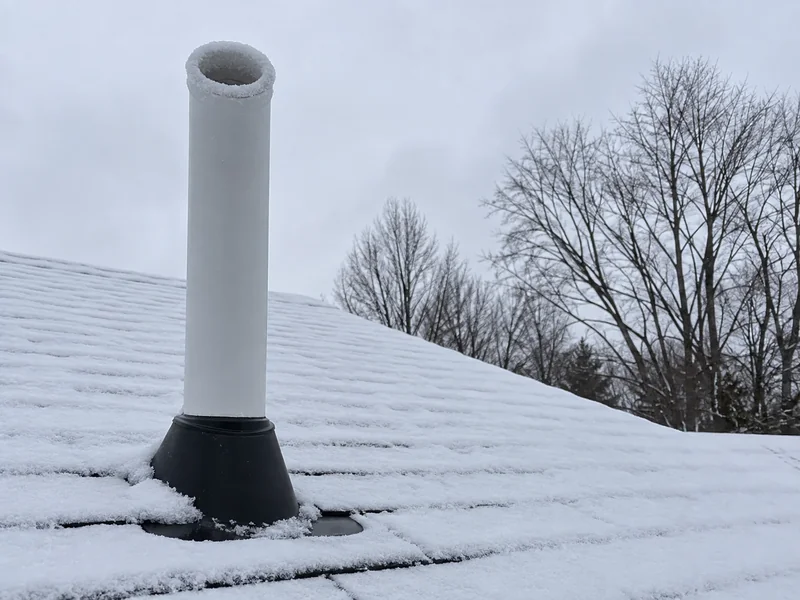 Radon vent pipe through a snow-covered Minnesota roof